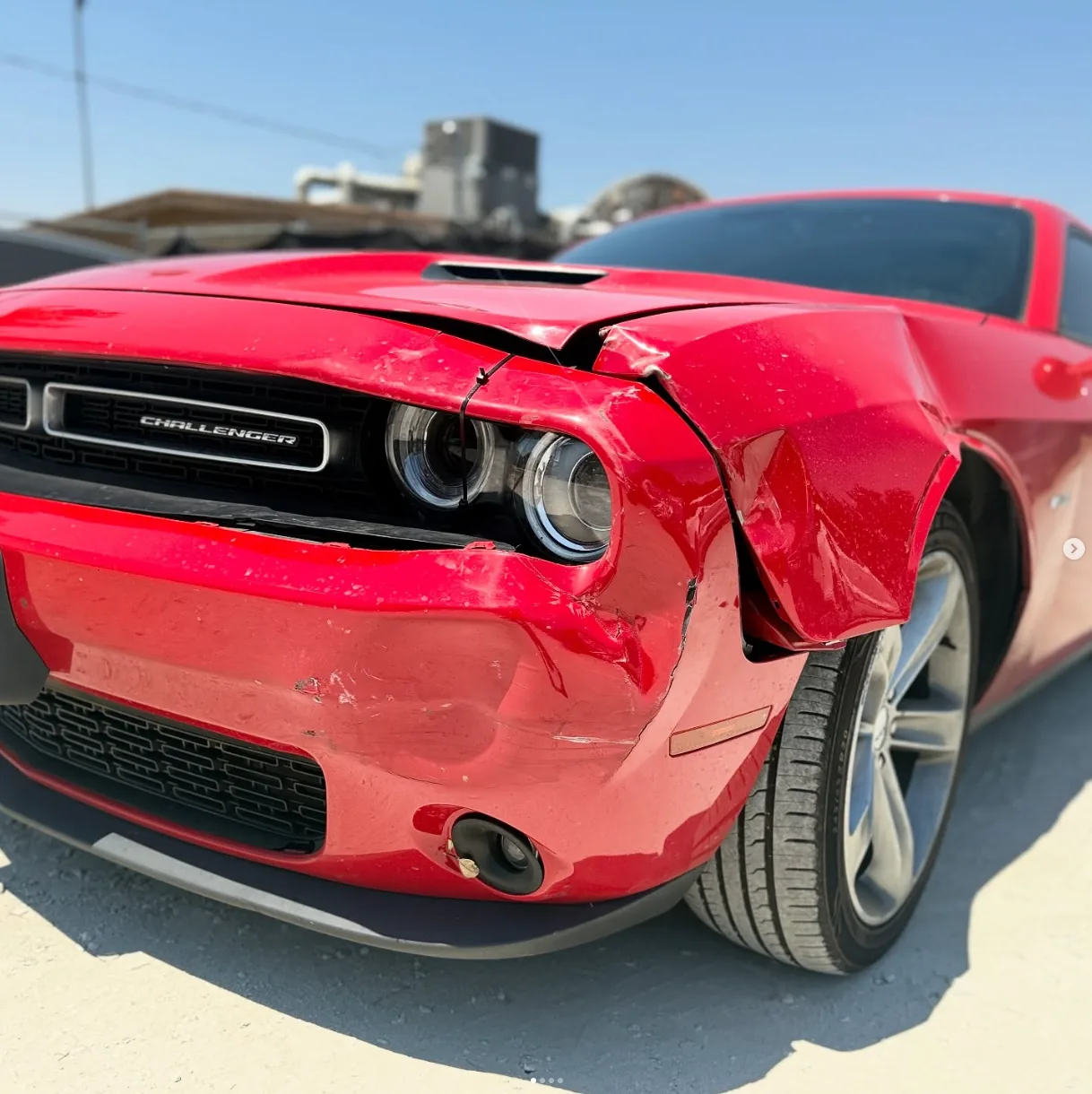 Front-corner collision damage on the same Dodge Challenger before repair.